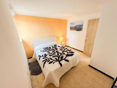 a bedroom with a bed with a black and white blanket at Casa Rural Gandia in Bocairent