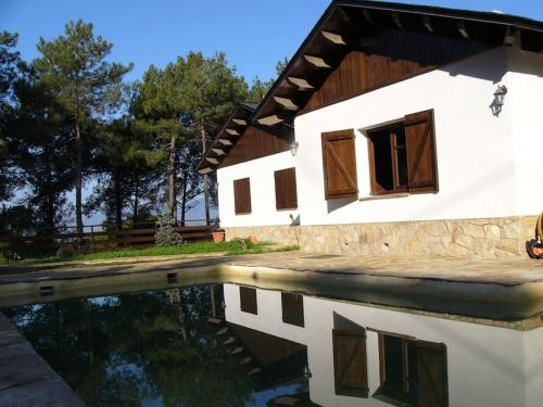 a house with a reflection in a pool of water at L'AMAGATALL DEL MONTNEGRE in Villalba Saserra