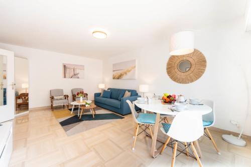 un salon avec une table et un canapé bleu dans l'établissement 2-Br Quiet Infinity Pool & Private Parking, à Cannes