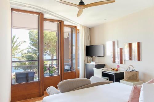 a living room with a couch and chairs and a tv at Hotel de Mar Gran Meliá - Adults Only - The Leading Hotels of the World in Illetas