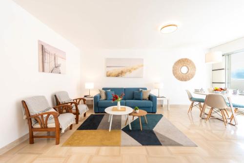 un salon avec un canapé bleu et des chaises dans l'établissement 2-Br Quiet Infinity Pool & Private Parking, à Cannes
