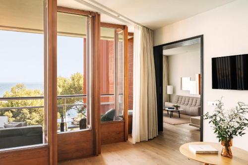 a living room with a sliding glass door with a view at Hotel de Mar Gran Meliá - Adults Only - The Leading Hotels of the World in Illetas