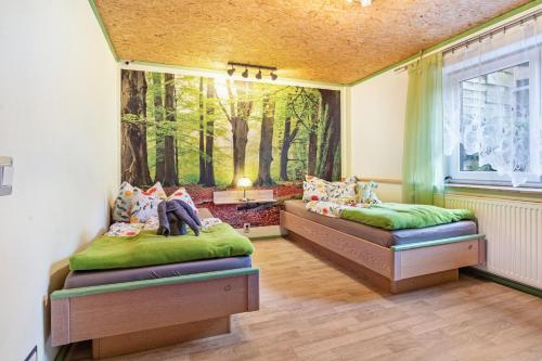 two beds in a room with a painting on the wall at Große Ferienwohnung mit Garten in Trollenhagen