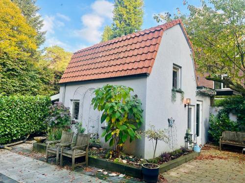 a small white house with a red roof at In de aap gelogeerd in Apeldoorn