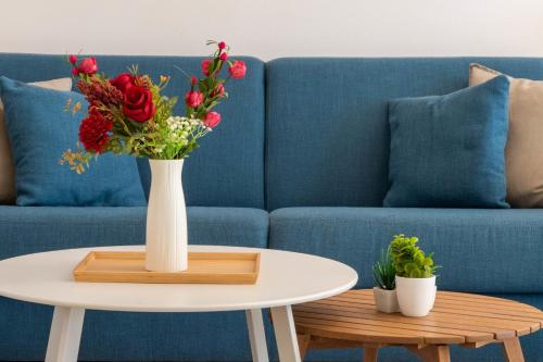 un vase de fleurs sur une table à côté d'un canapé dans l'établissement 2-Br Quiet Infinity Pool & Private Parking, à Cannes