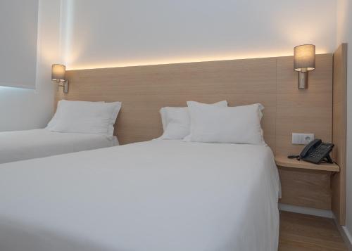 a hotel room with two beds and a telephone at Flag Hotel Lisboa Sintra in Sintra