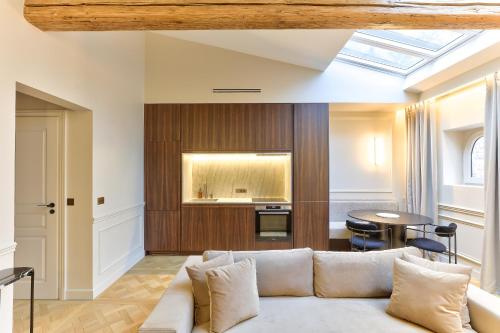 a living room with a couch and a table at Maison Iéna - Serviced Apartments on Champs Elysées in Paris