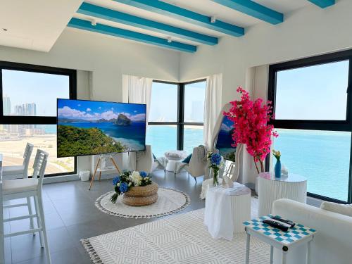 a living room with a large screen tv in it at The Blue City 1BR - Al Reem Island Beach View in Abu Dhabi