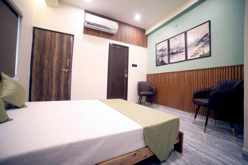 a room with a bed and two chairs in it at Bharat Milap Home Stay in Varanasi