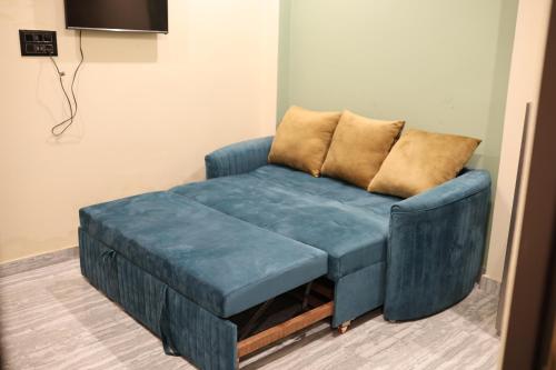 a blue couch with a foot stool in a room at Bharat Milap Home Stay in Varanasi