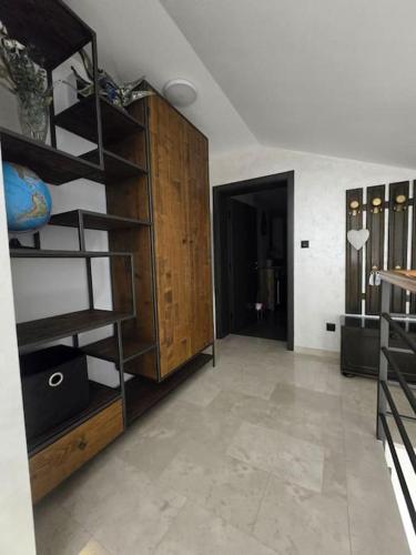 a room with a wooden book shelf and a hallway at Pepper Apartman Donji Miholjac in Donji Miholjac