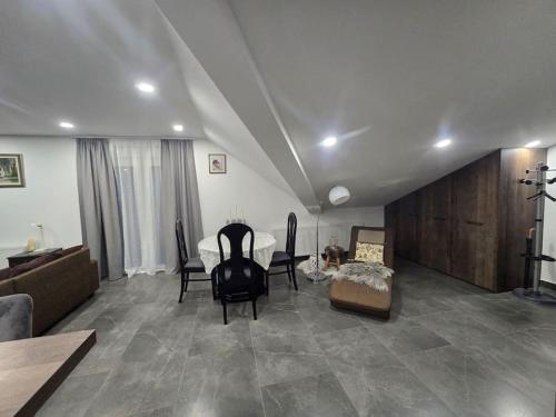 a living room with a couch and a table and chairs at Pepper Apartman Donji Miholjac in Donji Miholjac