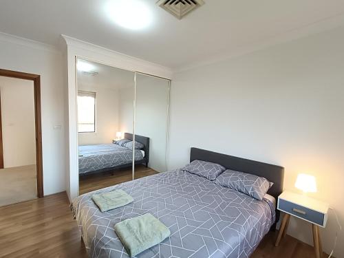 Ένα ή περισσότερα κρεβάτια σε δωμάτιο στο Cozy Queen Room in Spacious Merrylands Home - M4