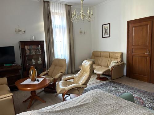 a living room with a bed and chairs and a table at Rózsakert Vendégház in Celldömölk