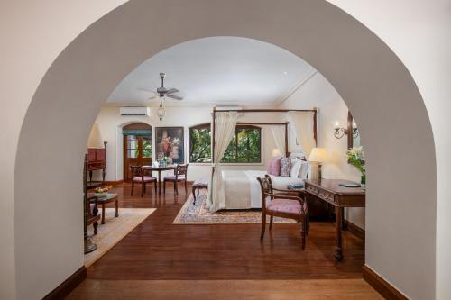an archway leading to a bedroom with a bed and a desk at Gateway Madurai in Madurai