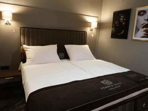 a bedroom with a large bed with white sheets and pillows at Hotel Mieszko in Gorzów Wielkopolski