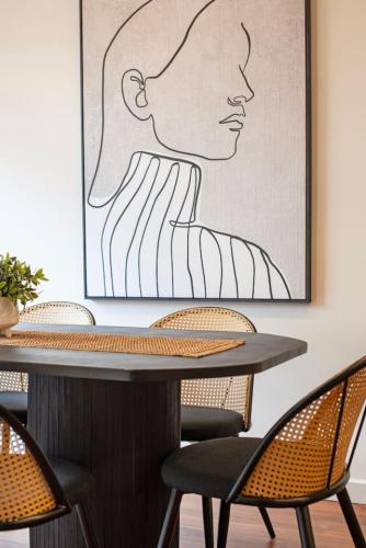 a table with chairs and a picture of a woman at Splendour in Norwood in Norwood