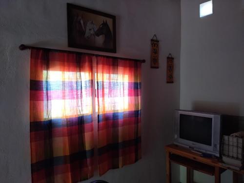 a colorful curtain in a room with a television at Che Sy ha Che Ru in Cosquín