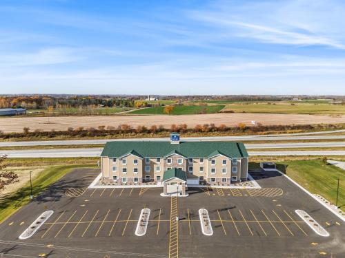 an aerial view of a building with a parking lot at Cobblestone Hotel & Suites Denmark - Green Bay in Denmark