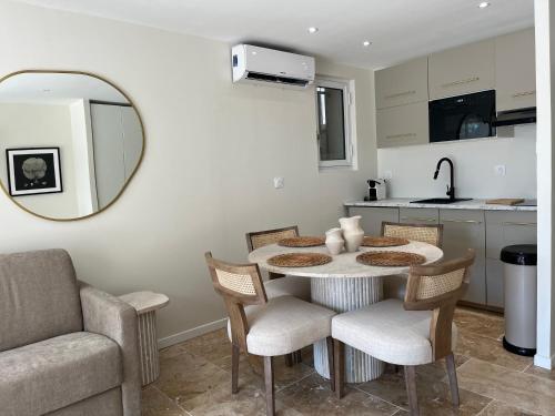 - une cuisine avec une table, des chaises et un miroir dans l'établissement Les Studios Famandiers, à Saint-Raphaël