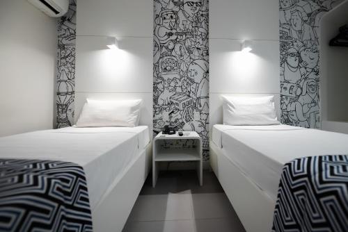 two twin beds in a room with a table at ibis Styles Rio de Janeiro Botafogo in Rio de Janeiro