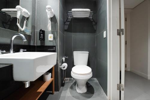 a bathroom with a white toilet and a sink at ibis Styles Rio de Janeiro Botafogo in Rio de Janeiro