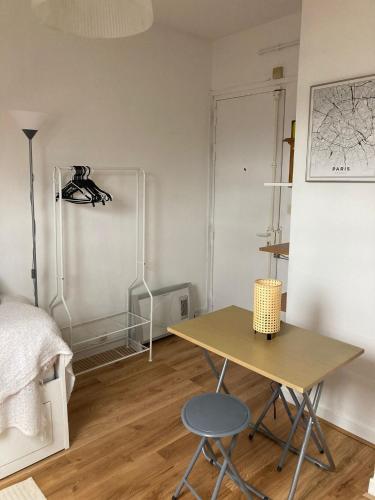 Cette chambre comprend un bureau, un lit et une table. dans l'établissement Ravissant studio Montmartre Opéra, à Paris