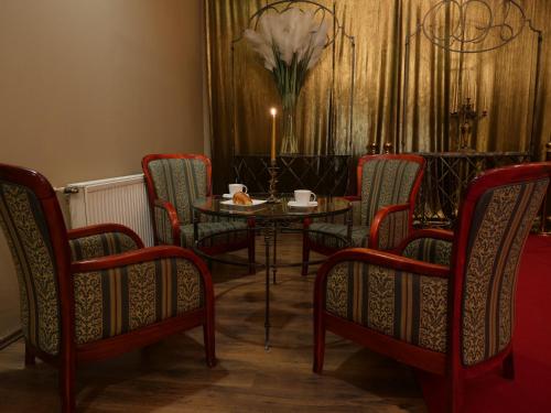 a dining room with a table and chairs and a vase of flowers at Hotel Mieszko in Gorzów Wielkopolski