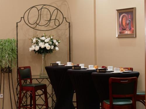 a table with chairs and a vase of flowers at Hotel Mieszko in Gorzów Wielkopolski