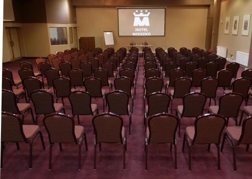 an empty room with chairs and a projection screen at Hotel Mieszko in Gorzów Wielkopolski