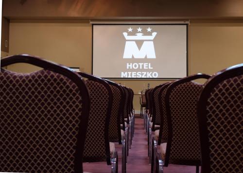 a row of chairs in a room with a projector screen at Hotel Mieszko in Gorzów Wielkopolski