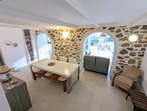 un salon avec une table et un mur en pierre dans l'établissement NEW - La Calmeraie - entre Pierre et Mer, à Bandol