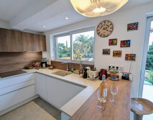 une cuisine avec une horloge et un comptoir avec des verres à vin dans l'établissement NEW - La Calmeraie - entre Pierre et Mer, à Bandol
