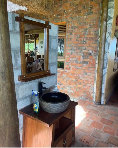 ein Badezimmer mit einem Waschbecken in einer Ziegelwand in der Unterkunft warujojo safari lodge in Malamagambo