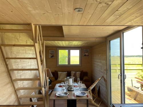 a dining room with a table and stairs in a house at Chalet charmant à Sainte-Marie-du-Mont avec terrasse in Sainte-Marie-du-Mont