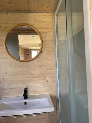 une salle de bain avec un lavabo et un miroir dans l'établissement Chalet charmant à Sainte-Marie-du-Mont avec terrasse, à Sainte-Marie-du-Mont