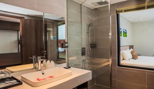a bathroom with a sink and a shower at Vipol Mui Ne Hotel & Spa in Mui Ne