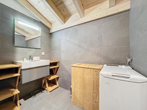 une salle de bain avec un lavabo et une machine à laver dans l'établissement Le Seraya - 5 pers- pistes à proximité, aux Gets
