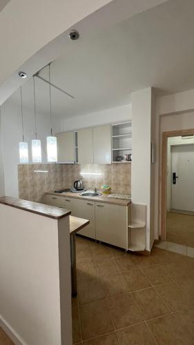 a kitchen with white cabinets and a table in it at Hana Apartment Ohrid in Ohrid