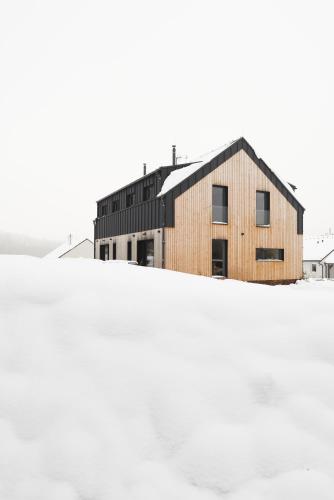 a building sitting on top of a snow covered field at Chalupa Nadohled in Červený Potok