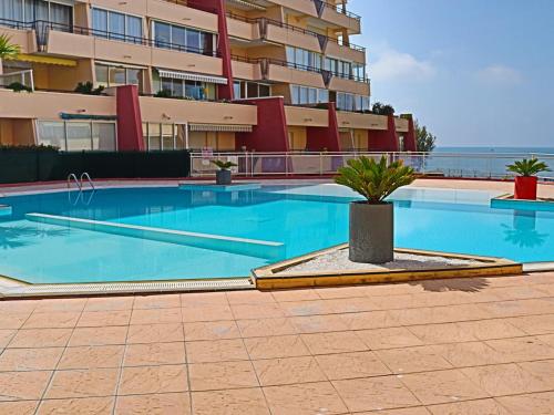 - une piscine en face d'un immeuble dans l'établissement Appartement 2 Pièces à Sète avec Terrasse, Piscine et Parking à 100m de la Plage - FR-1-472A-186, à Sète