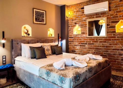 a bedroom with two beds and a brick wall at Къща за гости Casa La Tinozza in Hisarya