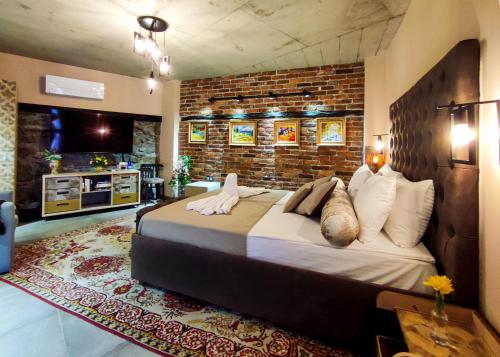 una camera da letto con un letto grande e un muro di mattoni di Къща за гости Casa La Tinozza a Hisarya