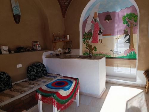 a room with a table and two chairs and a painting at Dream house in Luxor