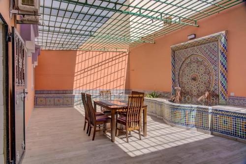 a patio with a table and chairs and a mosaic wall at jaws wave agadir 1 in Agadir