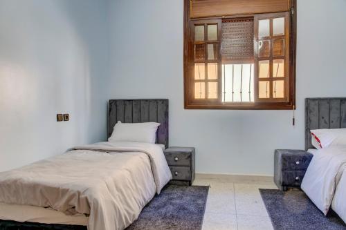 a bedroom with two beds and a window at jaws wave agadir 1 in Agadir