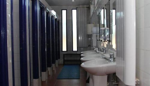 a bathroom with a row of sinks and mirrors at Albergue de Condemios de Arriba - Aventurarte in Condemios de Arriba