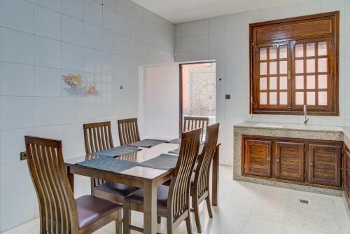 a dining room with a wooden table and chairs at jaws wave agadir 1 in Agadir