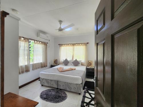 a bedroom with a bed and a desk and a door at Kaz Memel in Beau Vallon