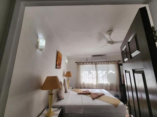 a bedroom with a bed and a window at Kaz Memel in Beau Vallon